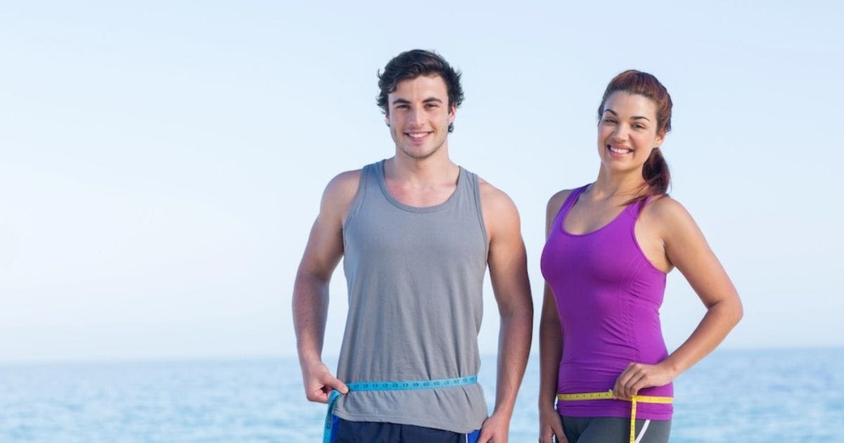 coppia che si chiede come perdere peso in modo sano e si misura il girovita con un metro