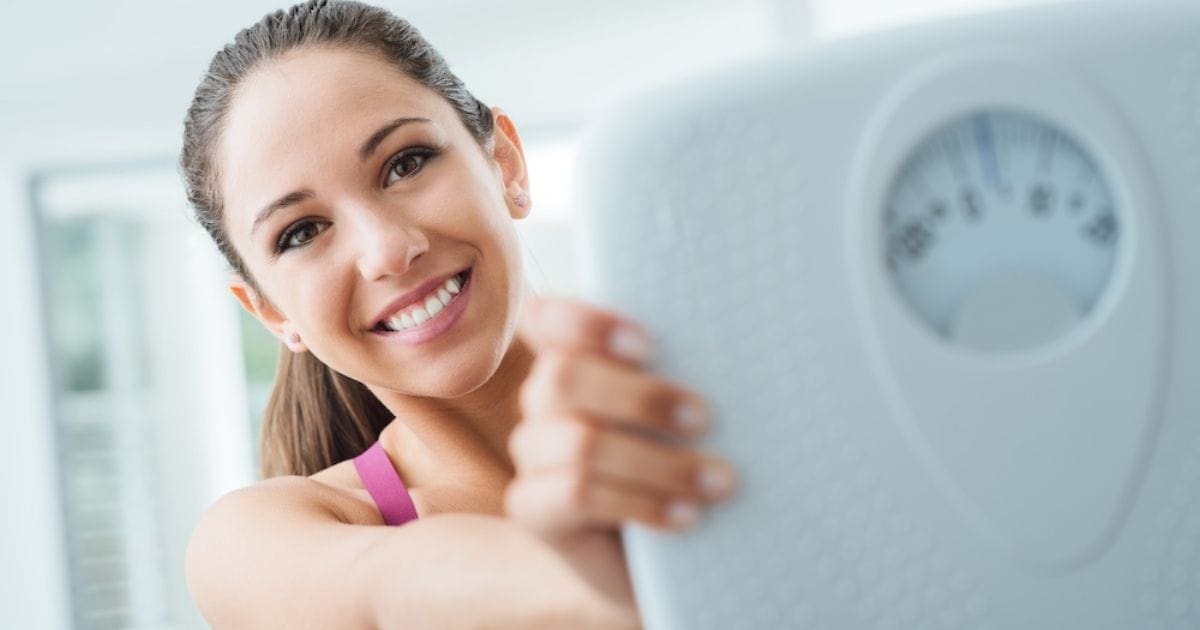 ragazza sorridente con bilancia in mano