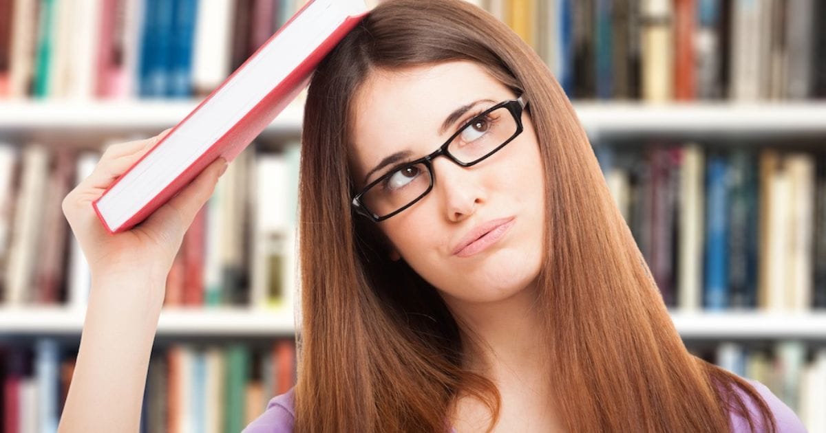 studentessa stanca con libro in testa