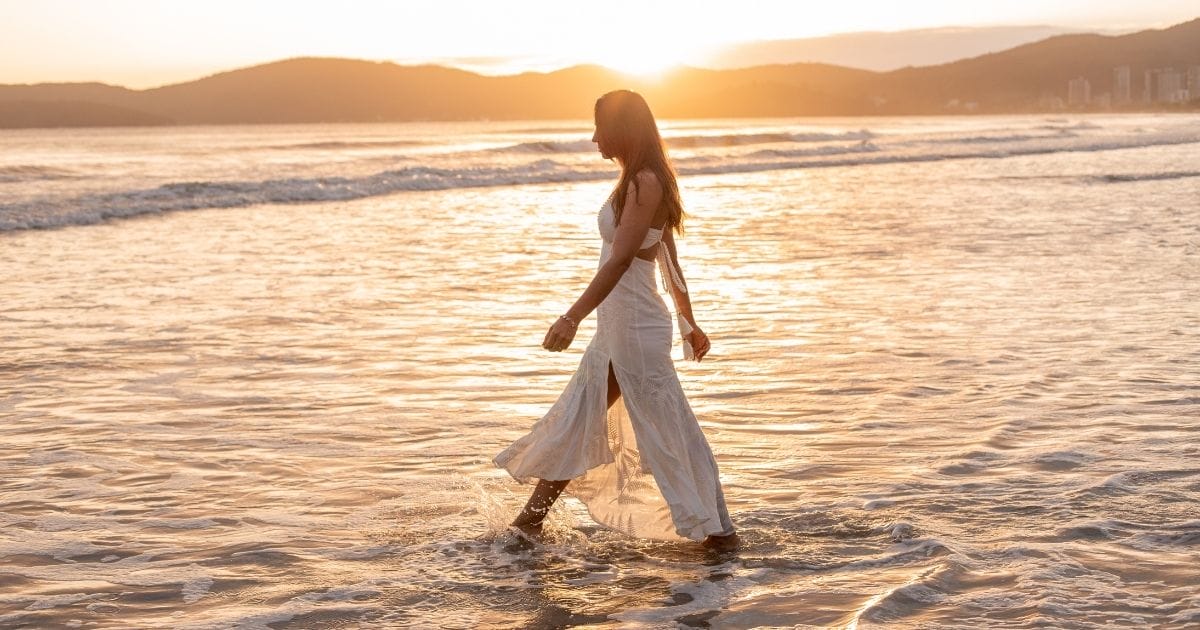 donna passeggia sulla spiaggia con gambe leggere