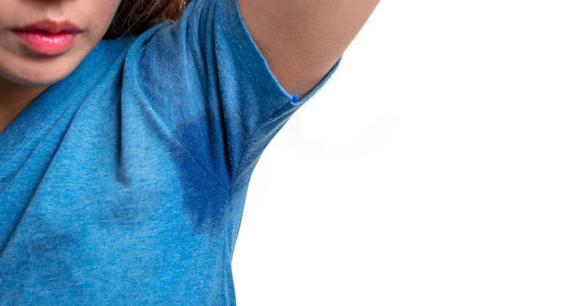 ragazza con braccio alto si nota macchia di sudore sull'ascella