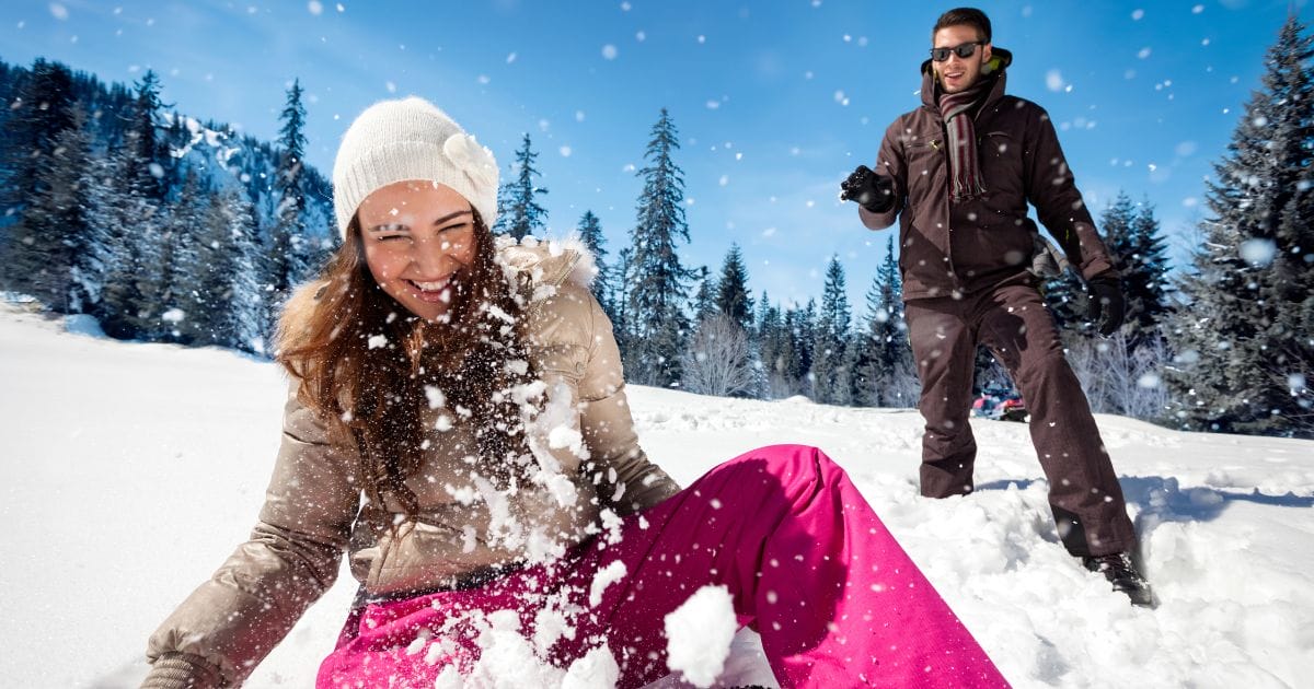 ragazzo e ragazza giocano sulla neve felici perché sono in salute durante l'inverno