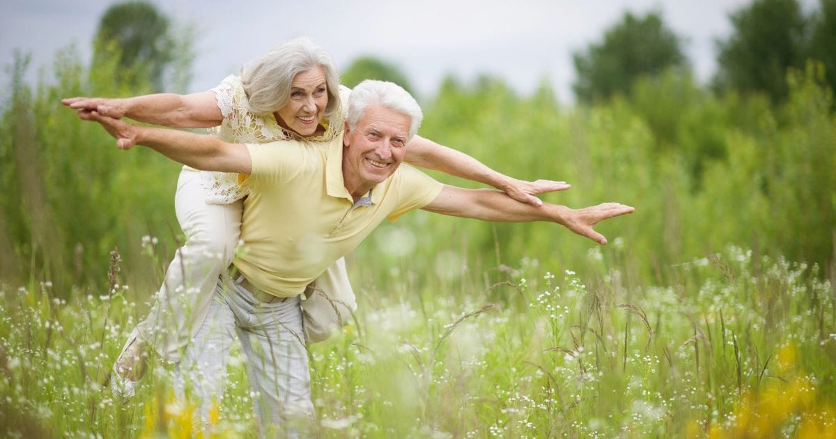 coppia gioca su un prato è energetica perché ha capito perché ci si sente stanchi in primavera e ha migliorato la propria vita