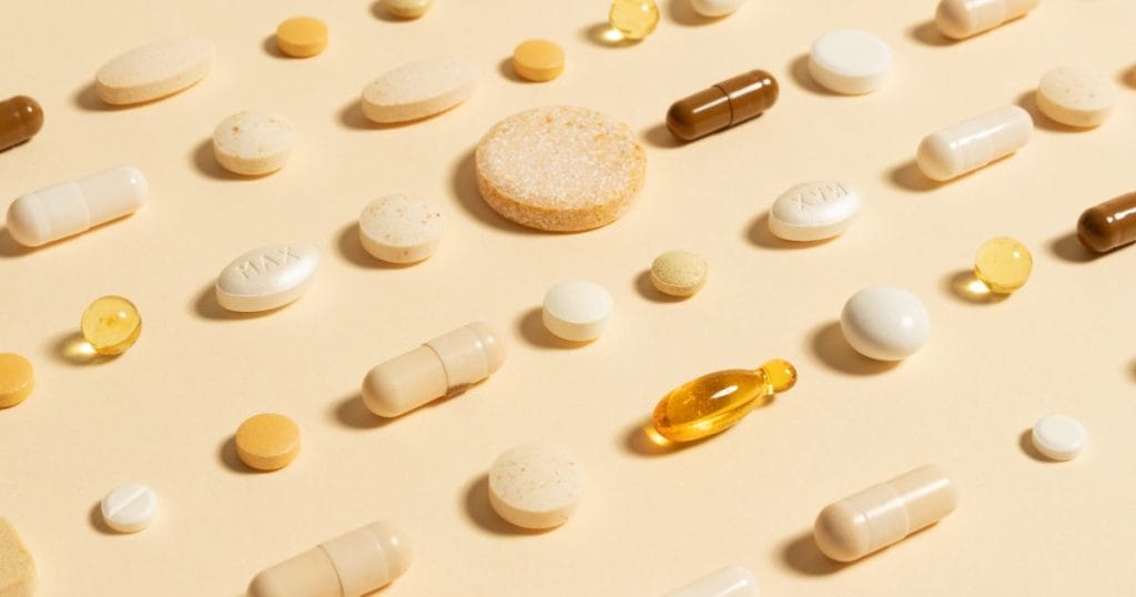 diverse forme di integratori in pastiglie su uno sfondo giallo
